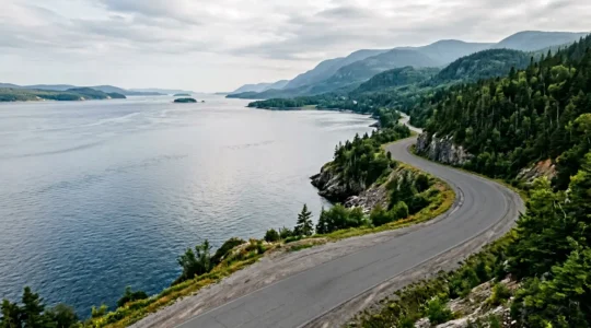 Vue panoramique d'une route côtière sinueuse au Québec longeant le fleuve Saint-Laurent avec un véhicule en mouvement